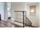 Bright hallway with wood-look flooring, iron railing, and stylish light fixture at 6349 N 78Th St # 105, Scottsdale, AZ 85250