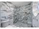 Elegant walk-in shower features marble-patterned tile surround, glass door, and built-in niche at 6349 N 78Th St # 105, Scottsdale, AZ 85250