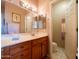 Bright bathroom with a large mirror, wooden vanity, and a view into the toilet and shower area at 6535 E Superstition Springs Blvd # 217, Mesa, AZ 85206