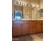 Bathroom vanity with wood cabinets, double sinks, and large mirror at 6535 E Superstition Springs Blvd # 217, Mesa, AZ 85206