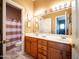 Well-lit bathroom with double sinks, wood cabinets, and a separate toilet and shower area at 6535 E Superstition Springs Blvd # 217, Mesa, AZ 85206
