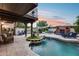 Beautiful backyard featuring a swimming pool, patio, outdoor fireplace, and lush landscaping at 6701 N Scottsdale Rd # 26, Scottsdale, AZ 85250