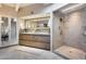 Bathroom featuring dual sinks, decorative mirror, walk-in glass enclosed shower with tile surround, and tile flooring at 6701 N Scottsdale Rd # 26, Scottsdale, AZ 85250