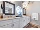 Modern bathroom with double sinks, white cabinets, a round window, and ample counter space at 6701 N Scottsdale Rd # 26, Scottsdale, AZ 85250