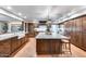 Open kitchen with a large island, custom wood cabinets, a farmhouse sink, and stainless steel appliances at 6701 N Scottsdale Rd # 26, Scottsdale, AZ 85250