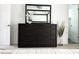 Contemporary bedroom with a dark wood dresser accented with a vase with decorative florals at 694 W Park Ave, Chandler, AZ 85225