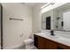 Modern bathroom featuring sleek fixtures, wood vanity, and a tiled shower with black accents at 7179 W Surrey Ave, Peoria, AZ 85381