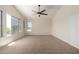 Sunlit bedroom showcasing large windows and a ceiling fan at 7179 W Surrey Ave, Peoria, AZ 85381