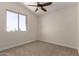 Well-lit bedroom featuring neutral carpet, trim, and a window for natural light at 7179 W Surrey Ave, Peoria, AZ 85381