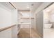 Walk-in closet with custom shelving and hanging space, next to bathroom at 7179 W Surrey Ave, Peoria, AZ 85381