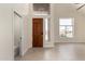 Bright entryway features a high ceiling, wood door and access to downstairs bath at 7179 W Surrey Ave, Peoria, AZ 85381