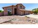Two-story home with a red tile roof, three-car garage, and desert landscaping at 7179 W Surrey Ave, Peoria, AZ 85381
