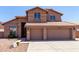 View of the two-story home with red tile roof, three-car garage and rock landscaping at 7179 W Surrey Ave, Peoria, AZ 85381