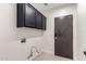 Functional laundry room with upper cabinets and utility connections at 7179 W Surrey Ave, Peoria, AZ 85381