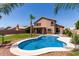 Backyard pool and patio area with palm trees, manicured lawn, and privacy fence at 7179 W Surrey Ave, Peoria, AZ 85381