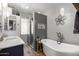 This modern bathroom features a freestanding tub, glass-walled shower, and gray tile at 7202 N 16Th Dr, Phoenix, AZ 85021