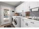Well-organized laundry room with modern washer/dryer, ample storage, and convenient sink and door access to outdoor pool area at 7202 N 16Th Dr, Phoenix, AZ 85021