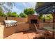 Outdoor dining area with a built-in grill and fireplace, creating a cozy and functional space for outdoor gatherings at 7202 N 16Th Dr, Phoenix, AZ 85021
