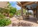 Covered brick patio with outdoor dining area, lush greenery, and seating at 7210 N 17Th Ave, Phoenix, AZ 85021