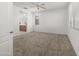 Spacious bedroom with neutral carpet and a ceiling fan, featuring natural light from the window at 7577 S Towel Creek Dr, Gold Canyon, AZ 85118