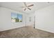 Bright bedroom features neutral carpet, a ceiling fan, and a window with outside views at 7577 S Towel Creek Dr, Gold Canyon, AZ 85118