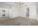 Well-lit bedroom features neutral carpet, ceiling fan, and access to the backyard patio at 7577 S Towel Creek Dr, Gold Canyon, AZ 85118
