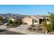 Attractive single-story home with a two-car garage, desert landscaping, and stunning mountain backdrop at 7577 S Towel Creek Dr, Gold Canyon, AZ 85118