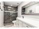Updated bathroom with tiled shower, glass door, white vanity with drawers, and a decorative framed mirror at 7736 E Rancho Vista Dr, Scottsdale, AZ 85251