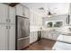 Well-lit kitchen features stainless steel appliances, white cabinets, and updated countertops with a marble backsplash at 7736 E Rancho Vista Dr, Scottsdale, AZ 85251
