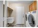 Well-lit laundry room with washer and dryer, utility sink, and ample storage at 8178 W Tonopah Dr, Peoria, AZ 85382