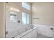 Modern walk-in shower with marble-style tile and clear glass enclosure at 8178 W Tonopah Dr, Peoria, AZ 85382