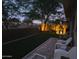 Night shot of a tranquil backyard featuring a stone patio and well lit plants at 8259 W Carol Ave, Peoria, AZ 85345
