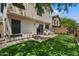 Backyard with artificial grass, stone patio, privacy wall, and mature trees at 8259 W Carol Ave, Peoria, AZ 85345