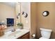 Cozy powder room featuring an updated vanity, toilet, and charming decorative accessories at 8259 W Carol Ave, Peoria, AZ 85345