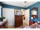 Comfortable bedroom with stylish furnishings, including a wooden dresser, a full closet and a serene atmosphere at 8259 W Carol Ave, Peoria, AZ 85345