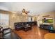 Spacious living room with wood flooring, comfortable leather couches, and large TV at 8259 W Carol Ave, Peoria, AZ 85345