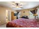 Spacious main bedroom with a ceiling fan and views to the ensuite bathroom at 8259 W Carol Ave, Peoria, AZ 85345
