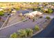 Aerial view of a desert home surrounded by well manicured greenery, fencing and paved driveway at 8351 S Summit Dr, Casa Grande, AZ 85193