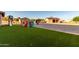 Lush green backyard with play equipment and storage buildings at 8351 S Summit Dr, Casa Grande, AZ 85193