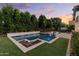 Gorgeous backyard with a sparkling pool, rock feature, hot tub, and lush artificial turf at 883 E Hampton Ln, Gilbert, AZ 85295