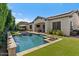 An inviting backyard with a sparkling pool, outdoor seating area, and lush artificial turf at 883 E Hampton Ln, Gilbert, AZ 85295