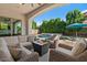Cozy backyard features a covered patio with a fire pit and refreshing pool view at 883 E Hampton Ln, Gilbert, AZ 85295
