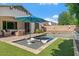 Beautiful backyard featuring a refreshing pool with loungers, covered patio, and well-maintained landscaping at 883 E Hampton Ln, Gilbert, AZ 85295