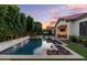 Expansive backyard featuring a sparkling pool, rock feature, and lush artificial turf at 883 E Hampton Ln, Gilbert, AZ 85295