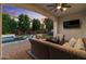 Luxurious outdoor living area featuring a covered patio, outdoor seating, and a beautiful swimming pool at 883 E Hampton Ln, Gilbert, AZ 85295