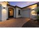 Close up of home's entrance and garage showing a wrought iron security door, exterior lighting, and mature palm tree at 883 E Hampton Ln, Gilbert, AZ 85295