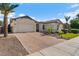 Inviting single-story home featuring a manicured front yard, paver driveway, and a two-car garage at 883 E Hampton Ln, Gilbert, AZ 85295