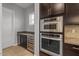 Kitchen includes built in oven with granite counters, dark cabinets, and beverage cooler at 883 E Hampton Ln, Gilbert, AZ 85295