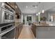 Modern kitchen with stainless appliances, granite counters, and bar overlooking dining area, offering a spacious layout at 883 E Hampton Ln, Gilbert, AZ 85295