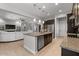 Bright kitchen boasts large island and stainless steel appliances with view to open concept living space at 883 E Hampton Ln, Gilbert, AZ 85295